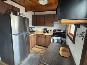 a kitchen with a stainless steel refrigerator and wooden cabinets at Snow Otter Haus - 2 in Bessemer