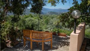 a wooden bench sitting on a patio with a view at Villa del noce - Dorgali in Dorgali