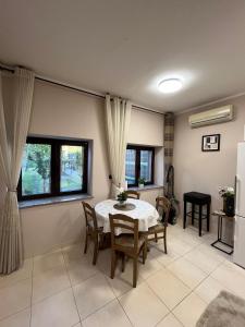 una sala da pranzo con un tavolo e alcune finestre di Stipos Apartment a Capodistria