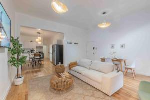 un salon avec un canapé blanc et une cuisine dans l'établissement City Escape with 2 Baths, 10 beds and We Pay Half Parking for 2 cars, NYC in 15 min, à Hoboken