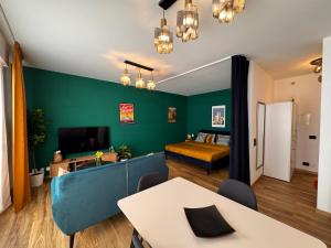 Una sala de estar con una pared de acento verde y un dormitorio. en Lakeside Lugano, en Lugano