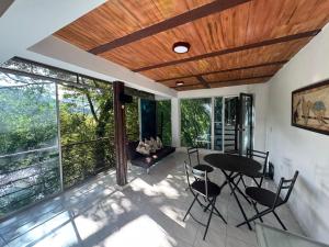 a living room with a table and chairs on a balcony at Cabaña Las Ceibas in Nocaima +26 photos