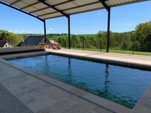 a swimming pool in a house with a roof at Gîte de la Forge, le Grenier in Fléré-la-Rivière
