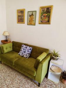 a green couch sitting in a living room at Piccola Casina in Oriolo