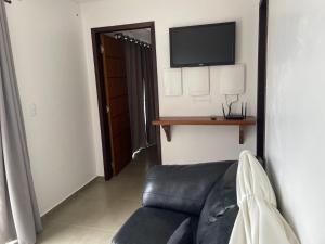 グァラトゥバにあるCasa surfのソファと薄型テレビのあるリビングルーム