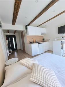 Suite cosy indépendante Evasion env Colmar في فينتزنهايم: غرفة نوم بسرير أبيض ومطبخ