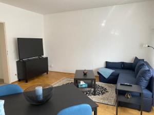 Una sala de estar con un sofá azul y un televisor en Cozy Apartment 6 at Cathedral, en Colonia