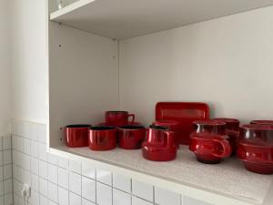 Un montón de tazas rojas en un estante en Cozy Apartment 6 at Cathedral, en Colonia 11 fotos más