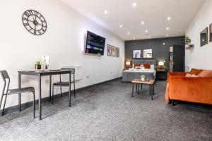 un soggiorno con letto e orologio a muro di RNM - Business Contractor Ready, Quiet, Private Access & Entire Place, Kitchen & Washroom with amenities, Smart Tv, Easy Access, Fast Starlink WiFi, Parking Nearby a Old Hill