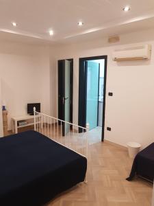 a bedroom with a black bed and a balcony at Centralissima casa Delfino in Gallipoli