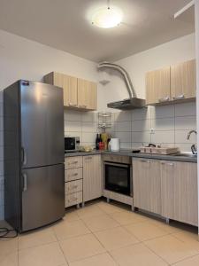 a kitchen with a stainless steel refrigerator and cabinets at Gemelli in Igalo +9 photos
