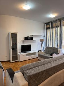 a living room with a couch and a tv at Gemelli in Igalo