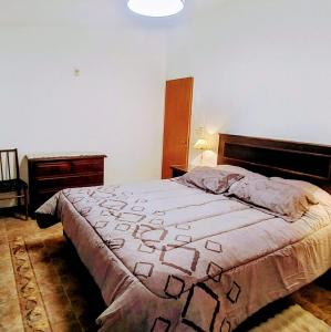 1 dormitorio con 1 cama en una habitación con lámpara en Esencia de Montaña, en El Challao