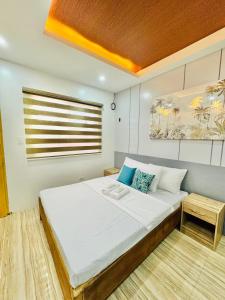 a bedroom with a large white bed and a window at Full House Santa Ana in Sampong