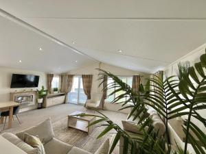 a living room with a couch and a tv at 2 Bed Caravan - Sleeps 6 - Pets - Pool - Parking in Newquay