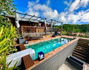 a swimming pool with a deck and a house at Gîte Santa Maria in Grand-Bourg