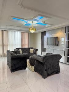 a living room with two couches and a chandelier at Cité La Vie in Douala