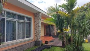 a house with a palm tree in front of it at Casa de hospedes 436 in Curitiba