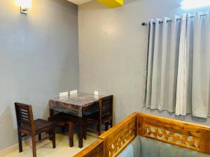 a dining room with a wooden table and chairs at Mj villa in Chennai