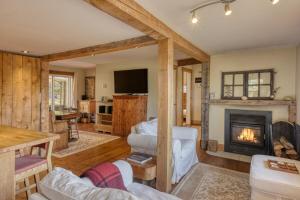 ein Wohnzimmer mit Kamin und Fernseher in der Unterkunft Cozy 3 bedroom cottage 8 min from North side Tremblant in Lac-Superieur