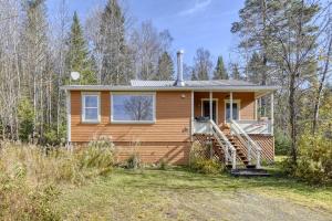 ein kleines Haus mitten auf einem Feld in der Unterkunft Cozy 3 bedroom cottage 8 min from North side Tremblant in Lac-Superieur