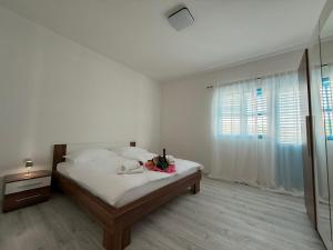 une chambre blanche avec un lit et une fenêtre dans l'établissement Mediterranean Blue Escape - 3BR Apartment with Balcony & Sea View, à Poljica