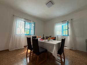 d'une salle à manger avec une table, des chaises et des fenêtres. dans l'établissement Mediterranean Blue Escape - 3BR Apartment with Balcony & Sea View, à Poljica 18 autres photos