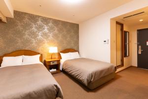a hotel room with two beds in a room at Hotel Bel Air Sendai in Sendai