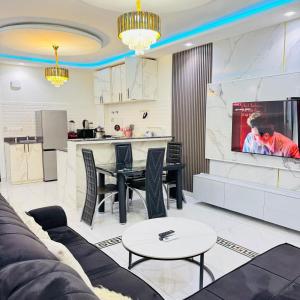 a living room with a table and a kitchen at Cité La Vie in Douala +29 photos