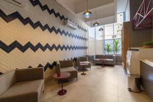 a waiting room with couches and chairs and a wall at 2206 - Studio | alto padrão in Guarulhos