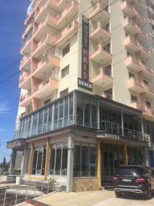 un hotel con un coche aparcado delante de él en Hotel Nais Beach, en Durrës