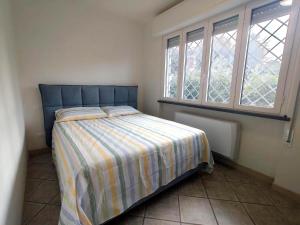 a small bedroom with a bed and two windows at Villino Ambra in Marina di Pietrasanta