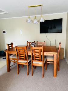 a dining room with a wooden table and chairs at Depto amoblado 3D 2B in San Pedro de la Paz