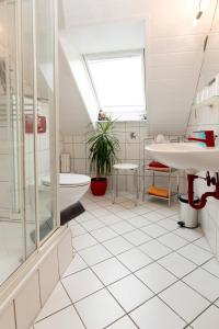 a white bathroom with a tub and a sink at Gästehaus Hauser in Rust