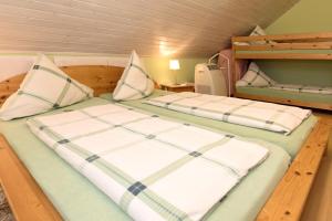 two beds in a small room with wooden floors at Gästehaus Hauser in Rust