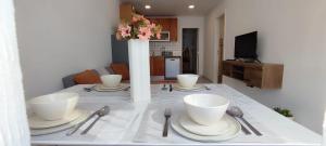 a table with plates and bowls and a vase on it at Casa Maria Olímpia in Nazaré