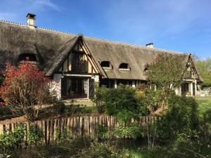 an old house with a thatched roof at L'Ile Normande in Hardencourt-Cocherel