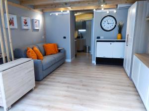 a living room with a couch and a clock on the wall at CityLoft Milano, two meters from metro station for the Duomo in Milan