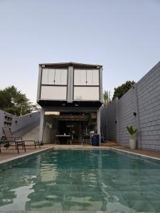 a house with a swimming pool in front of a house at Casa Container in Águas de Lindóia