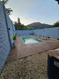 a swimming pool with two chairs next to a wall at Casa Container in Águas de Lindóia +24 photos