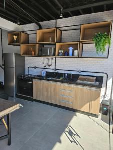 a kitchen with wooden cabinets and a stainless steel refrigerator at Casa Container in Águas de Lindóia
