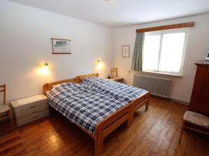 a bedroom with a bed with a checkered blanket at Landhaus Karawankenblick in Lukowitz