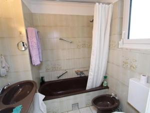 a bathroom with a bath tub and a sink at Landhaus Karawankenblick in Lukowitz