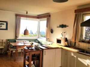 a kitchen and living room with a table and a window at Landhaus Karawankenblick in Lukowitz