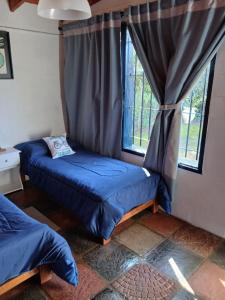 a room with two beds in front of a window at ALOJAMIENTO SERRANO BIS in Villa Giardino