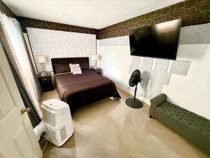 a bedroom with a bed and a flat screen tv at Miami Gardens Comfort Suite by Hard Rock Stadium in Miami Gardens