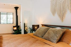 a bedroom with a bed with a pillow on it at Mystwood Spa Cabins in Wollombi +6 photos