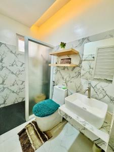 a bathroom with a toilet and a sink at Santa Ana Transient House in Sampong