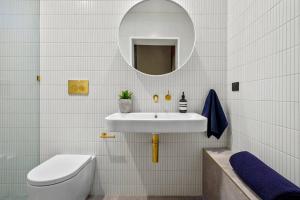 a bathroom with a sink and a toilet and a mirror at The Milliner - Boutique Living, Geelong West in Geelong West