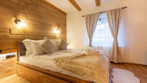 a bedroom with a bed with a wooden headboard and a window at Sun x Mountains - Old Town in Braşov